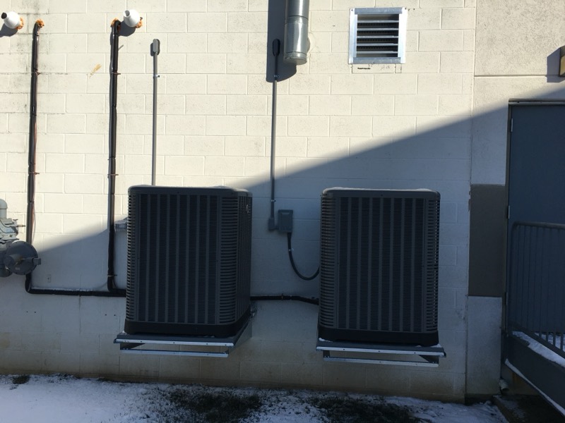 Twin condenser units on wall-mounted brackets